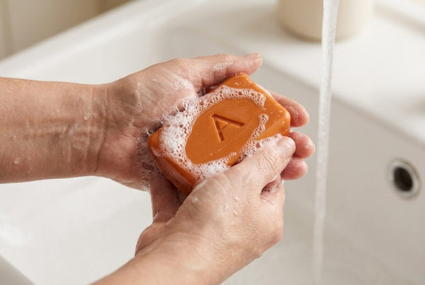 Wet hands working up a gentle soap lather with the Amevia persimmon bar