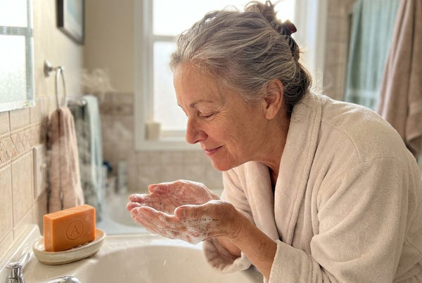 A woman breathing in the light, clean scent of the lather at her sink