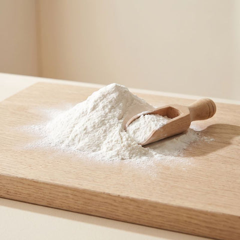 A soft mound of fine white powder with a wooden scoop