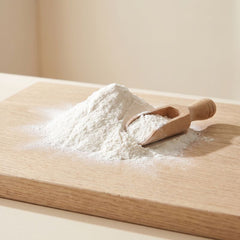 A soft mound of fine white powder with a wooden scoop