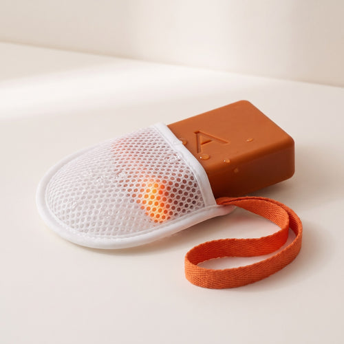 Amevia Persimmon Soap sliding out of the exfoliating mesh soap pouch