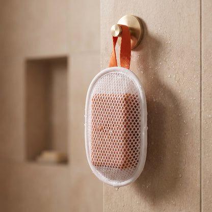 Amevia soap pouch hanging by its orange strap to dry in the shower